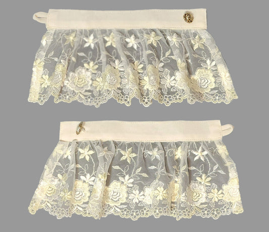 Two lace cuffs with floral patterns on a dark background