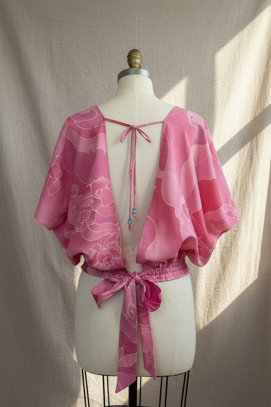 Pink floral dress on a mannequin against a gray background