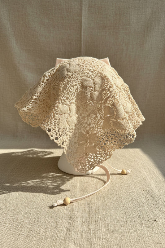 Beige lace head scarf back view on a plain background