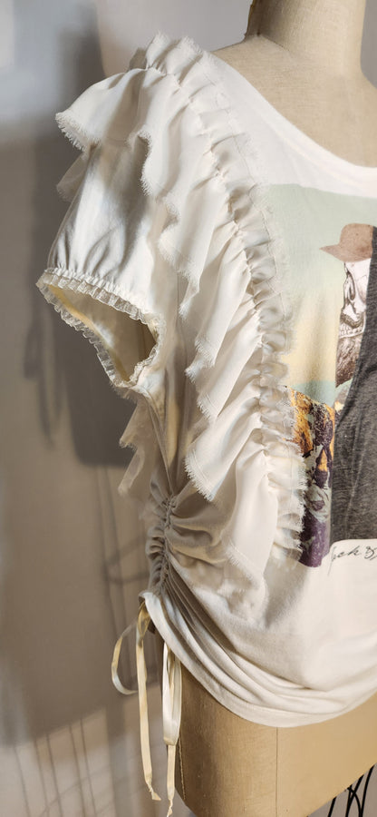 Mannequin wearing a white blouse with ruffled details on a neutral background