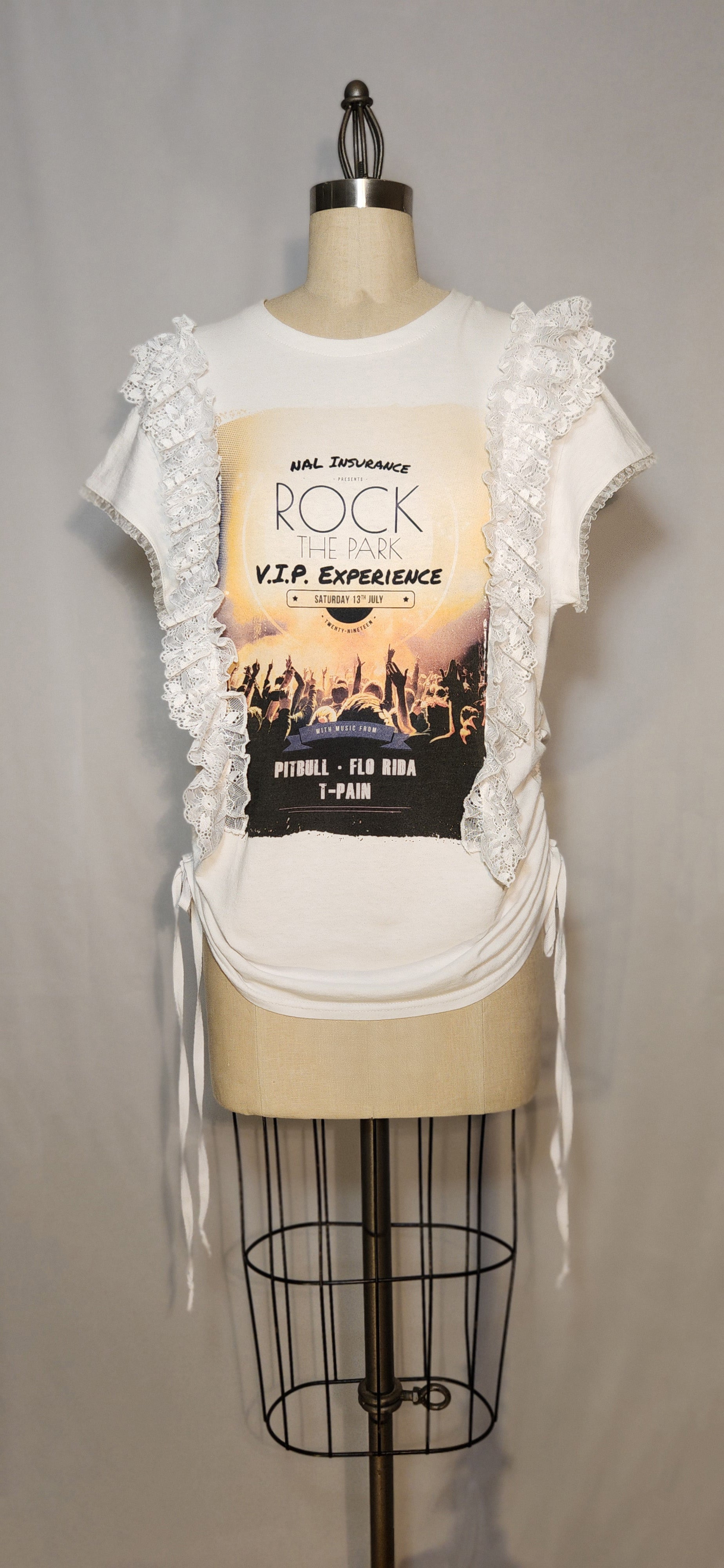 White lace-trimmed top on a mannequin with a concert poster design.