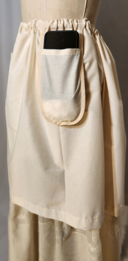 Beige apron with a pocket on a mannequin against a gray background