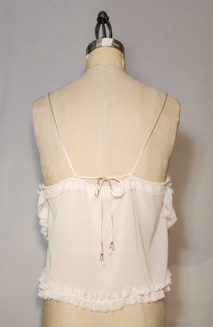 White lace top on a mannequin against a gray background