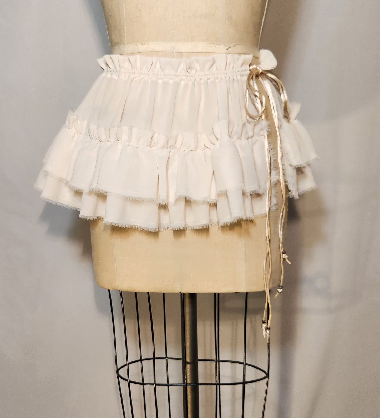 White ruffled skirt on a mannequin against a plain background