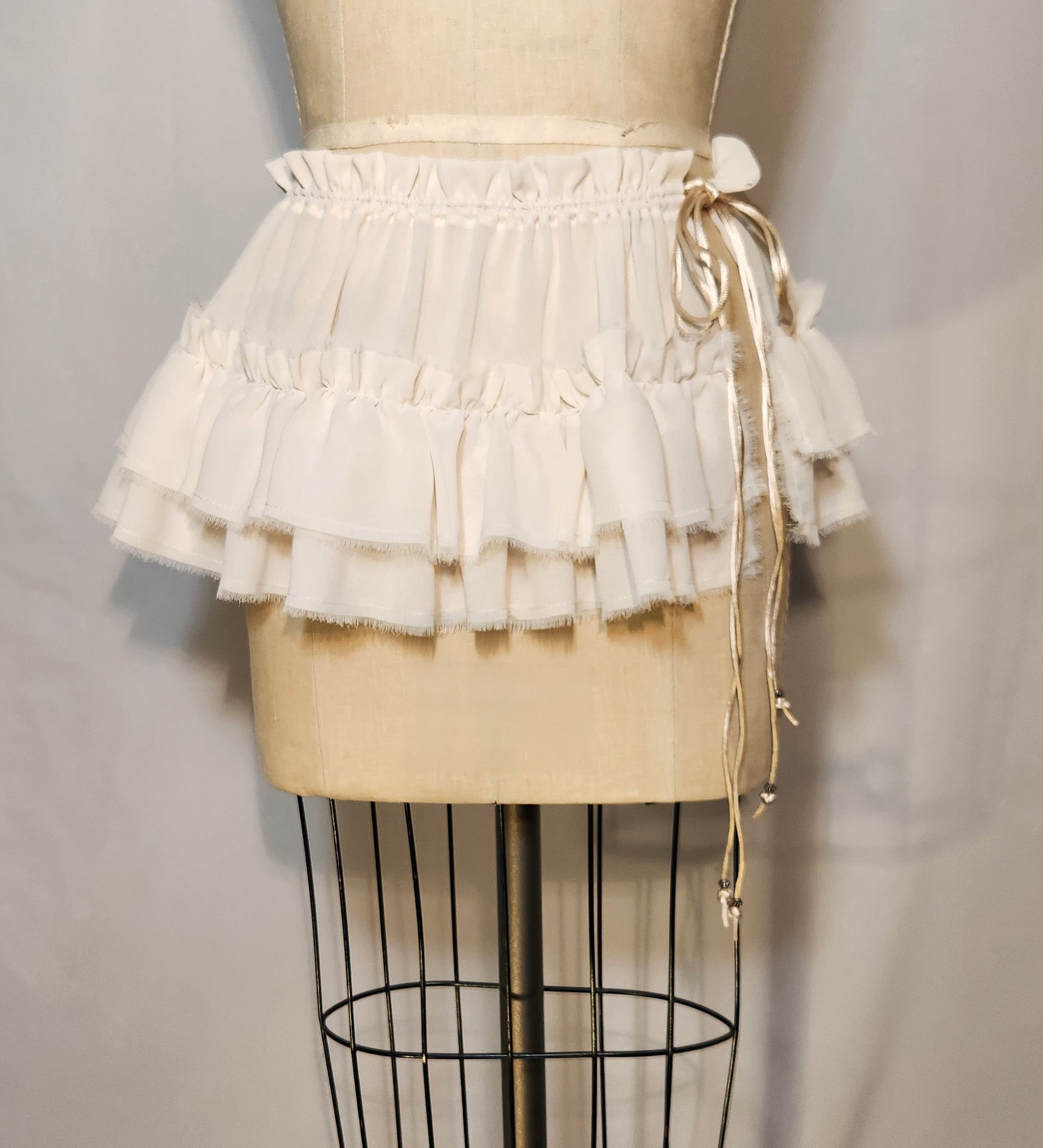 White ruffled skirt on a mannequin against a plain background