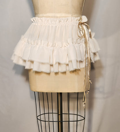 White ruffled skirt on a mannequin against a plain background