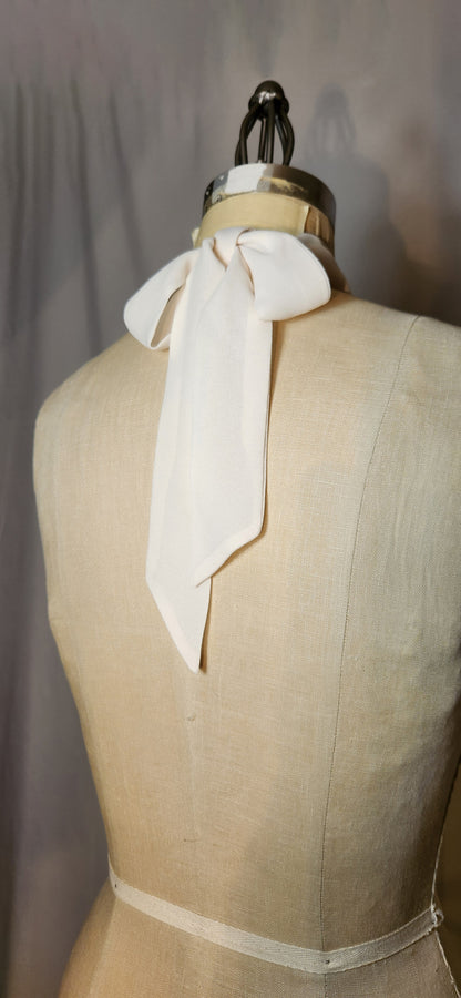 Mannequin wearing a cream-colored scarf with a plain background