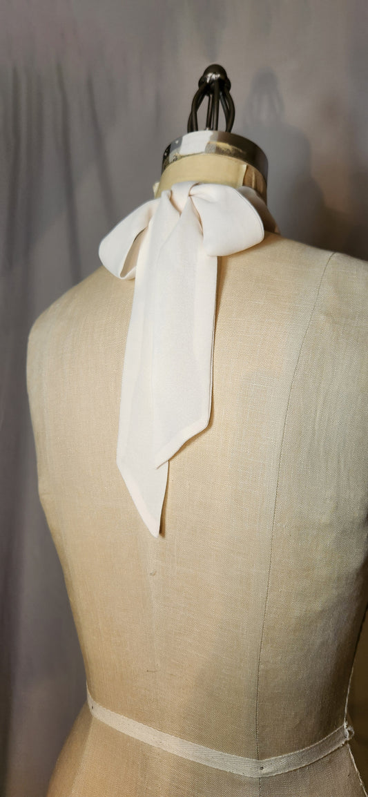 Mannequin wearing a cream-colored scarf with a plain background
