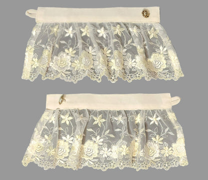 Two lace cuffs with floral patterns on a dark background