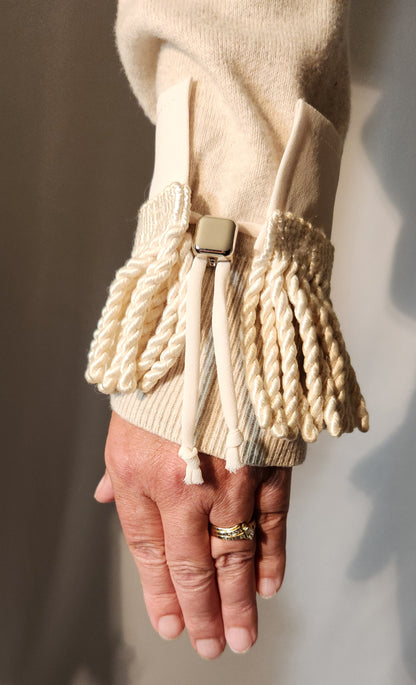 Beige woven wristlet with a button on a neutral background