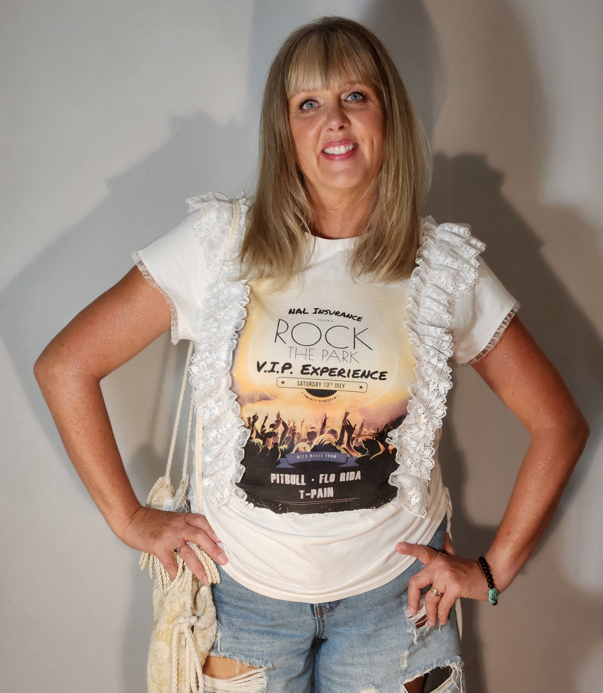 Woman wearing a white t-shirt with a graphic design, standing against a plain background