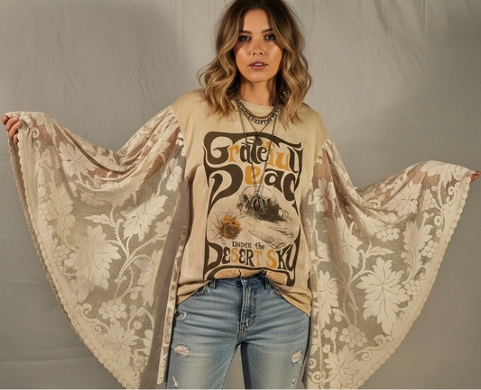 Woman wearing a graphic sweatshirt with a floral shawl over her shoulders against a plain background