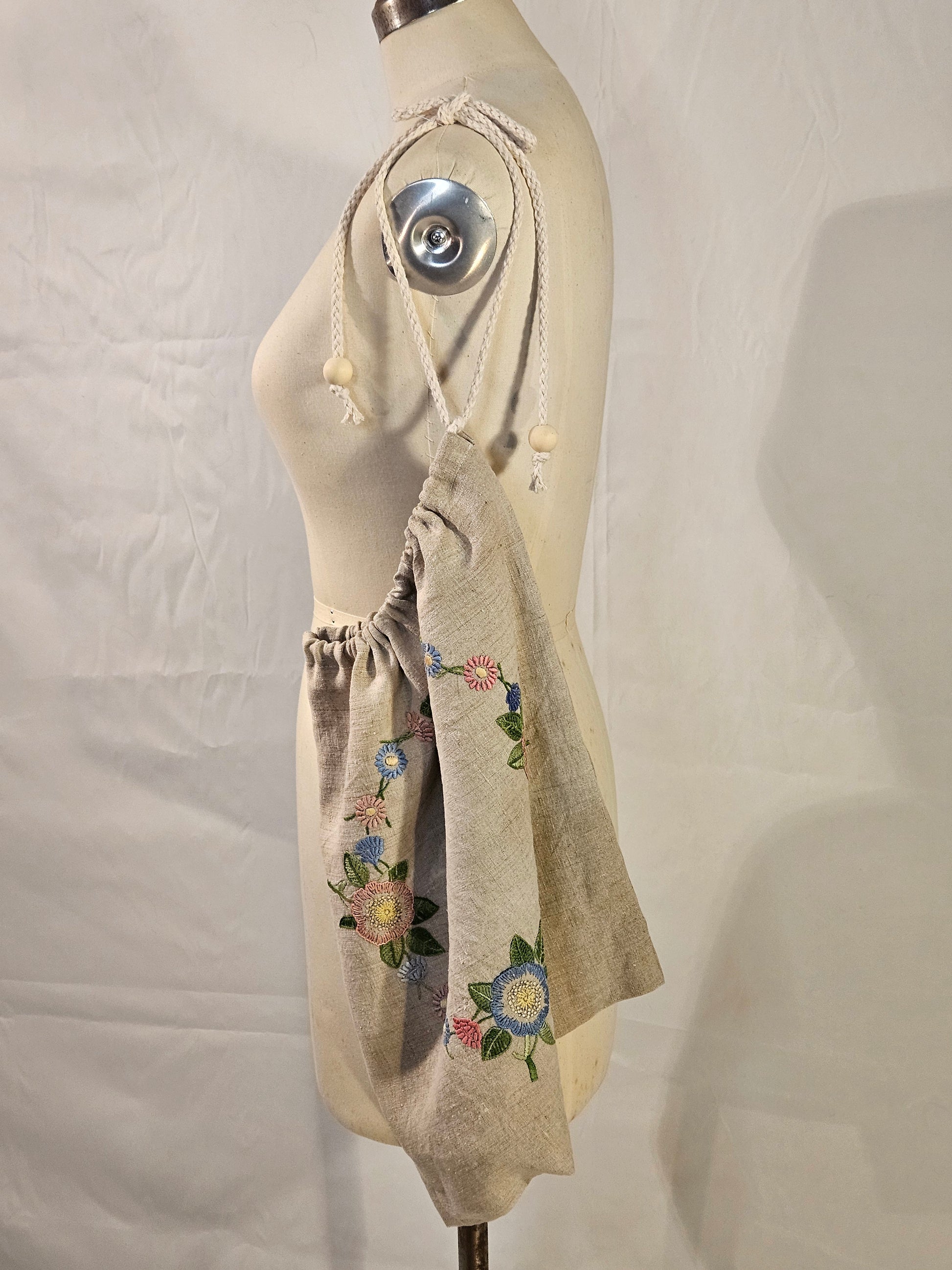 Embroidered fabric on a mannequin with floral designs against a plain background