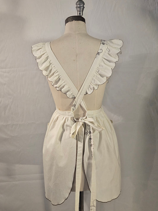 Mannequin wearing a cream-colored dress with ruffled details on a plain background