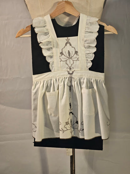 White apron with floral embroidery on a black background