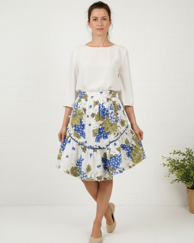 Woman wearing a white blouse and floral skirt on a beige background