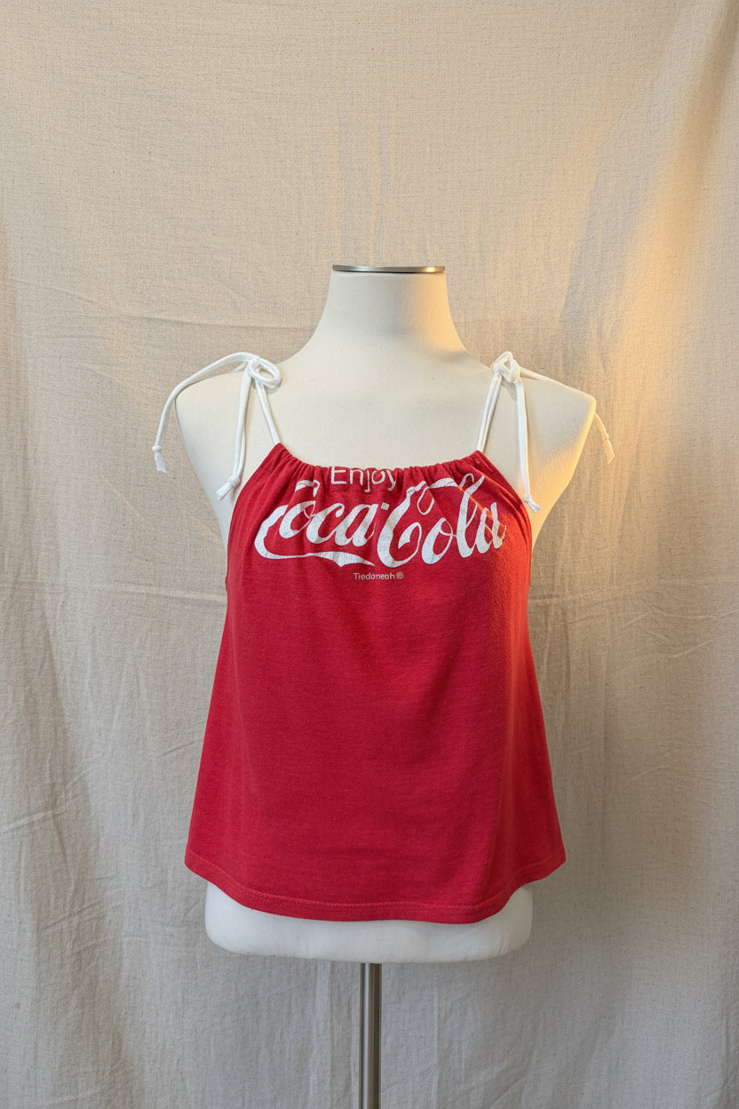 Red tank top with Coca-Cola logo on a mannequin against a neutral background