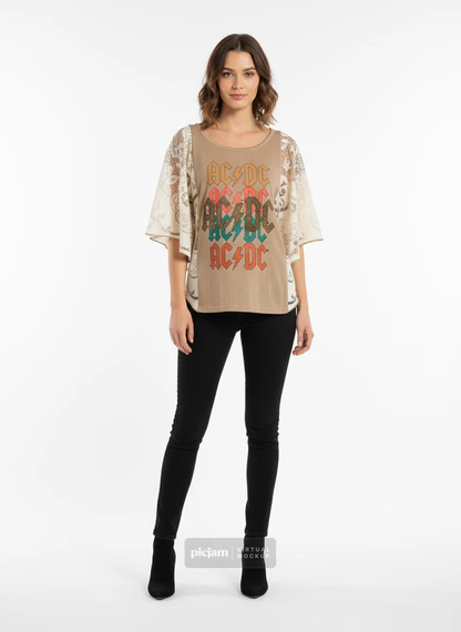 Woman wearing a beige blouse with AC/DC logo and black pants on a white background