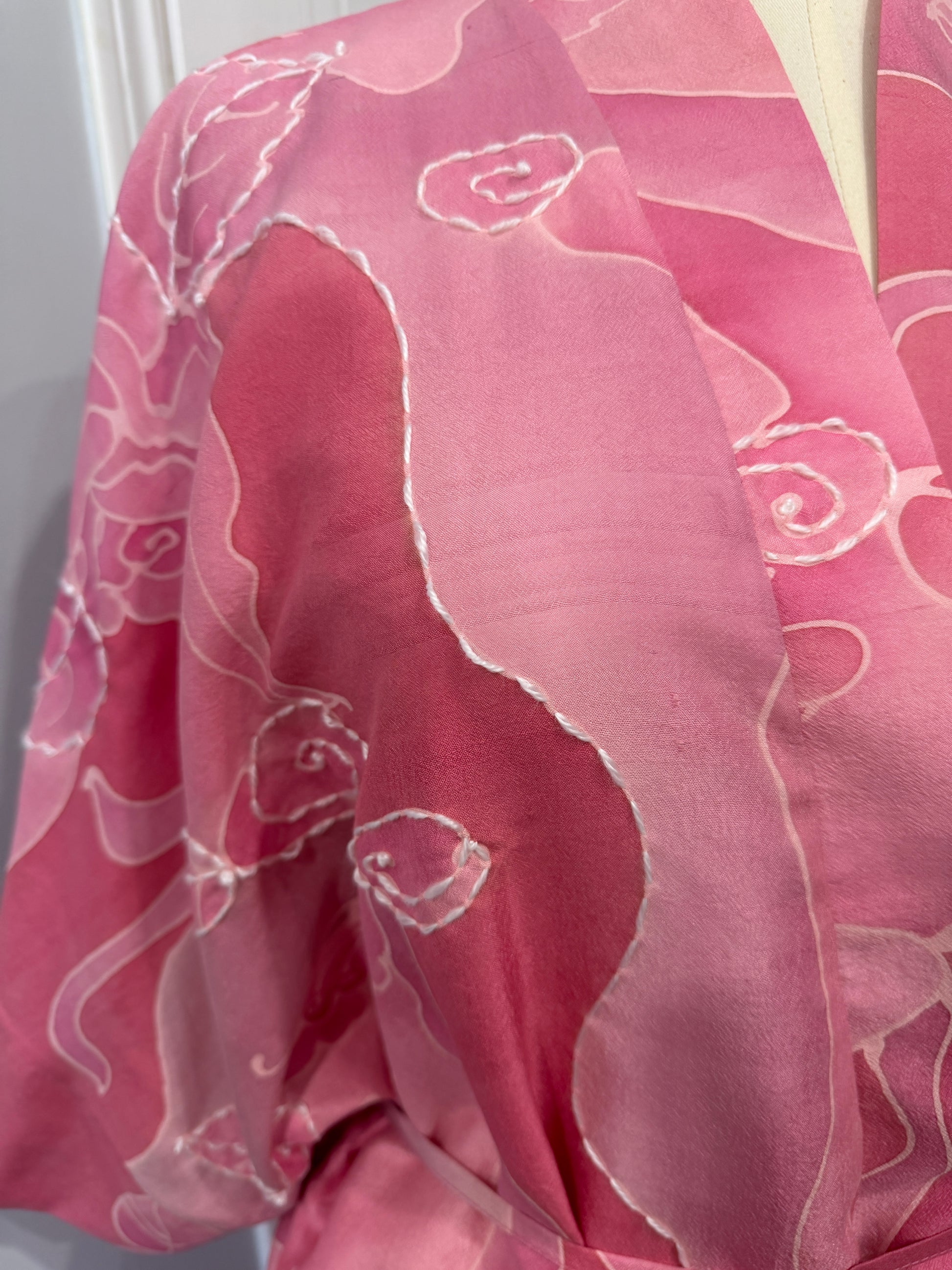 Pink fabric with white floral patterns on a white background