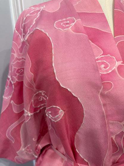 Pink fabric with white floral patterns on a white background