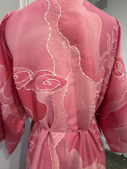 Pink fabric with white floral patterns on a gray background