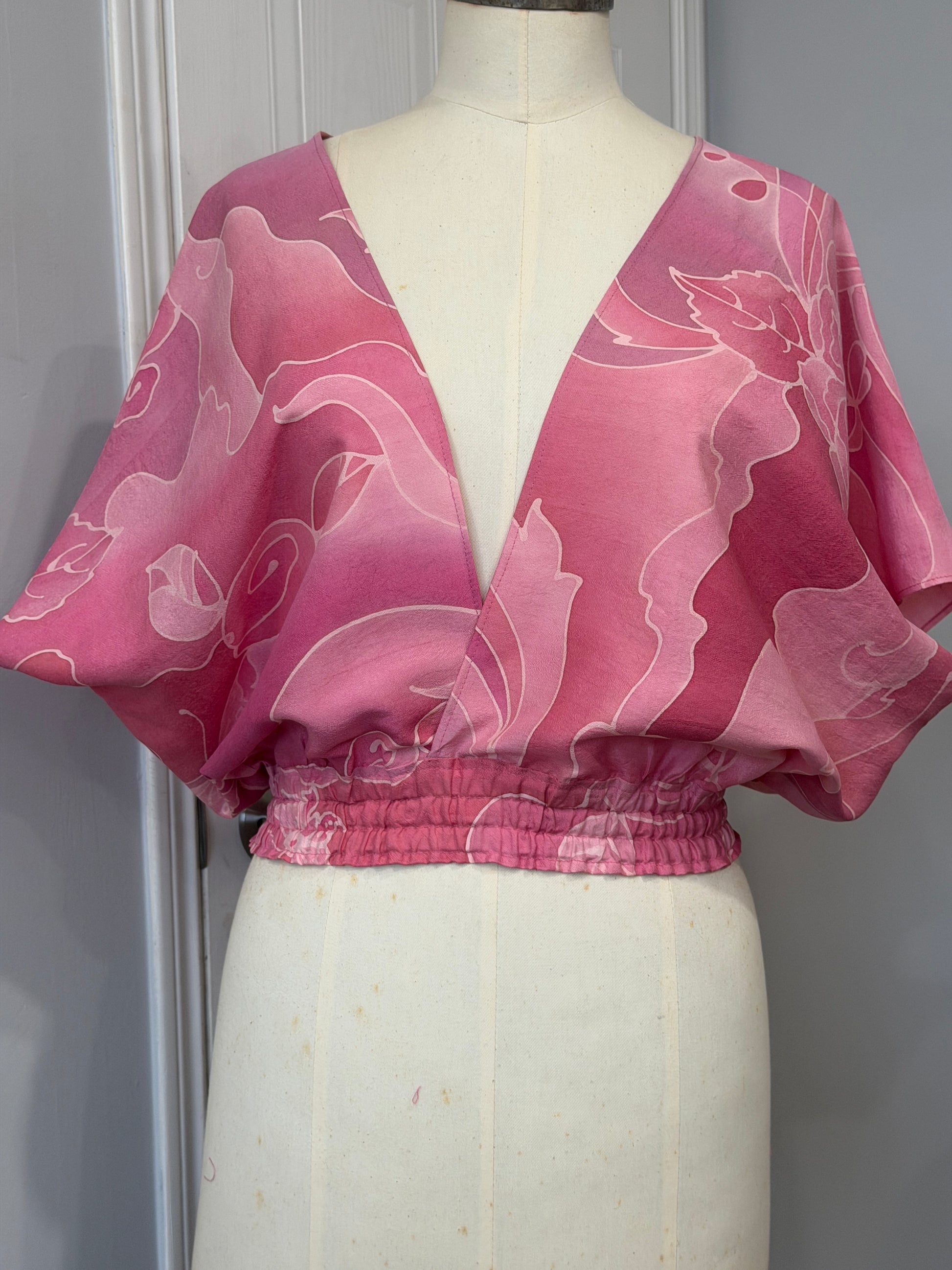 Pink floral dress on a mannequin against a gray background