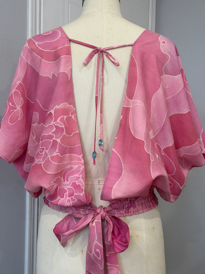 Pink floral dress on a mannequin against a gray background