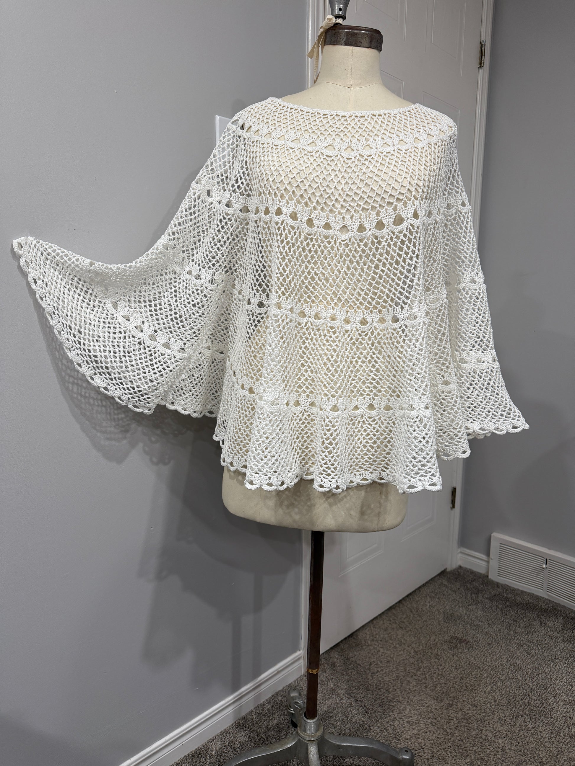 White lace garment on a mannequin against a neutral background