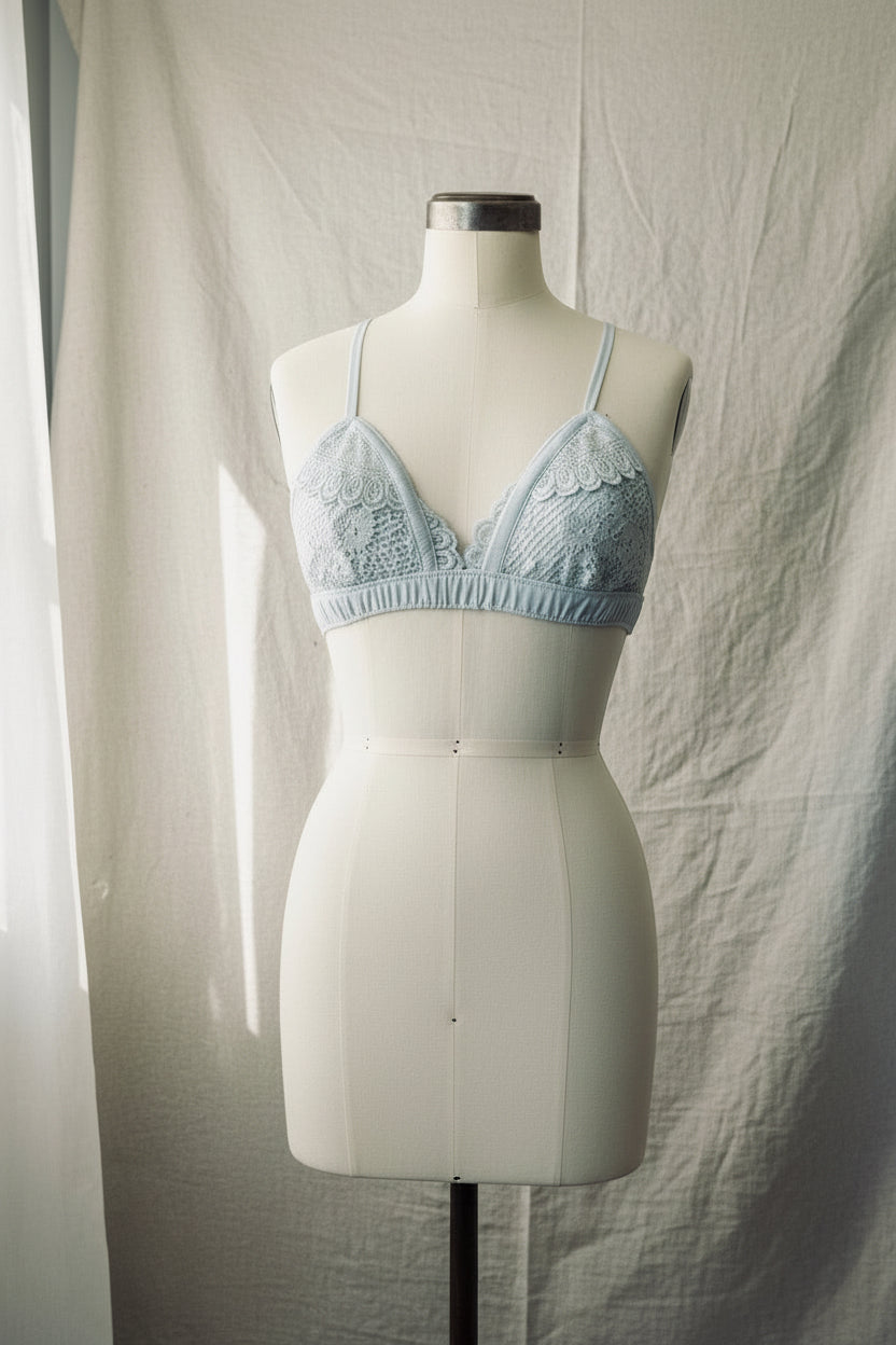 Light blue lace bra on a mannequin against a plain background