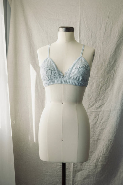 Light blue lace bra on a mannequin against a plain background