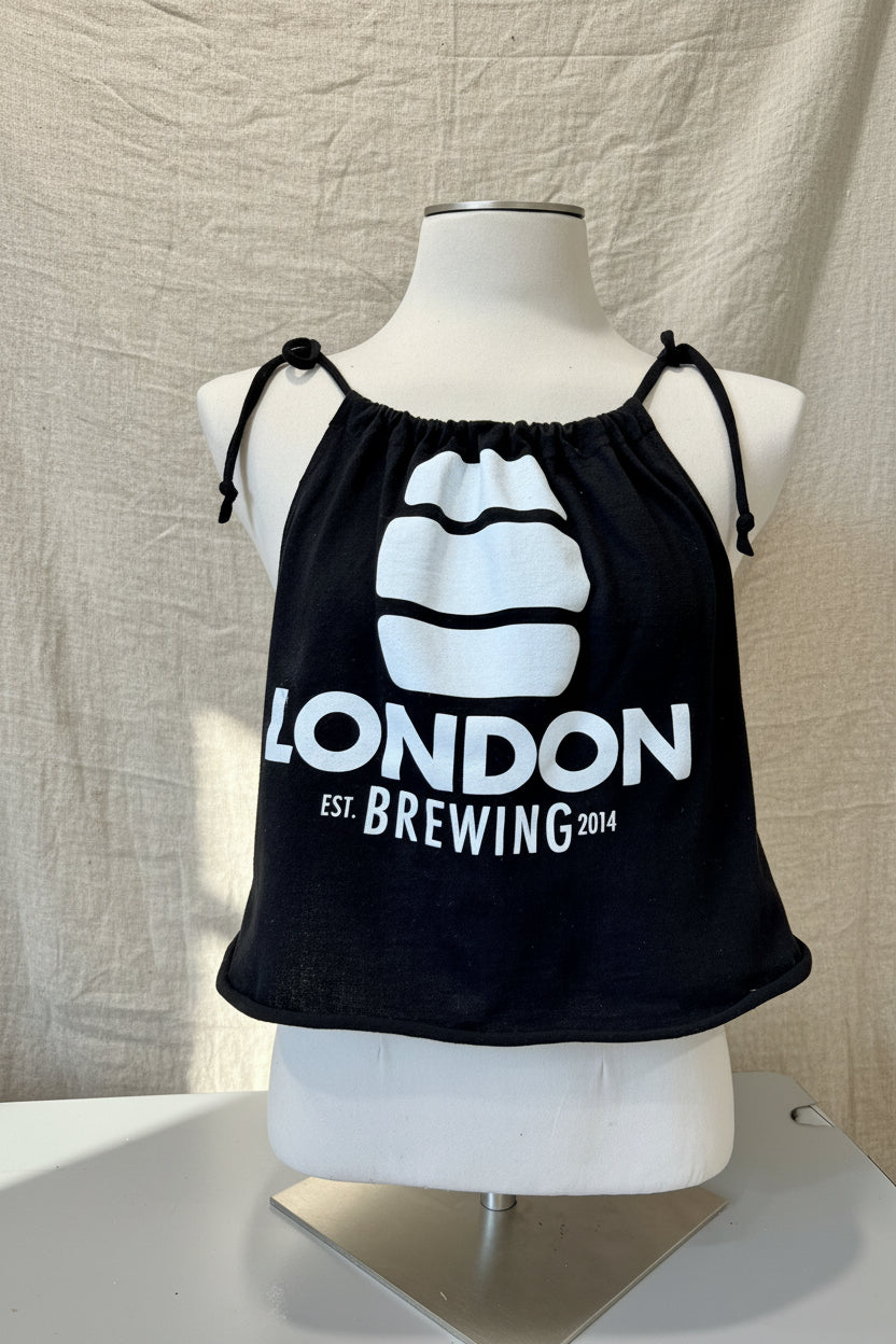 Black tank top with 'London Brewing' logo on a mannequin against a beige background