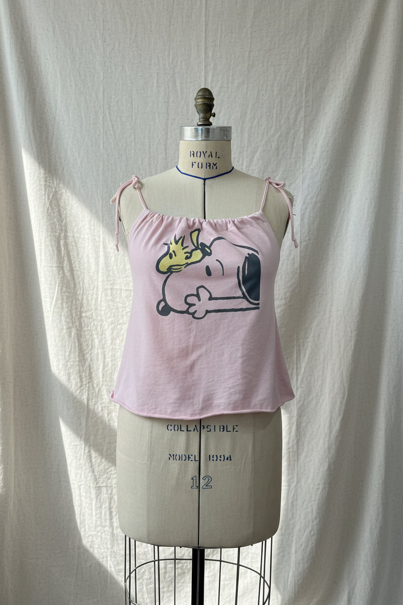 Pink tank top with cartoon design on a mannequin against a white curtain
