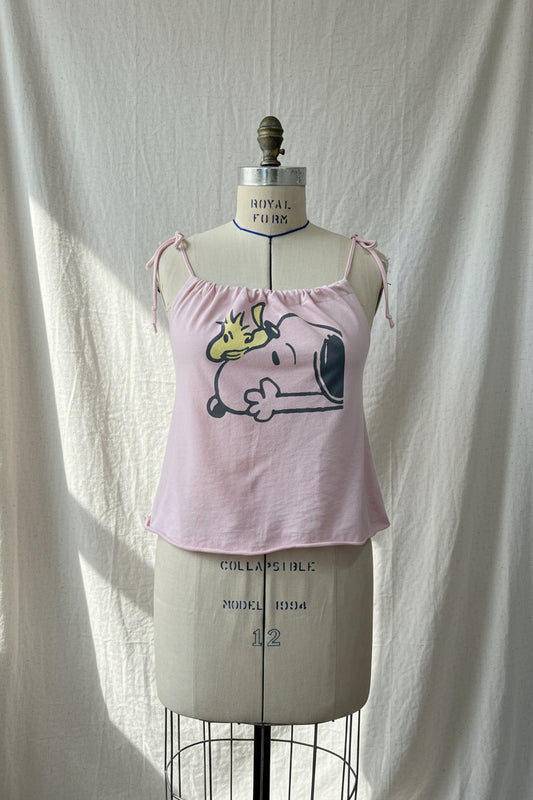 Pink tank top with cartoon design on a mannequin against a white curtain