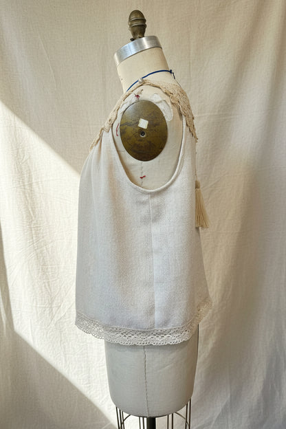 Ivory top with lace trim on a mannequin against a white curtain background