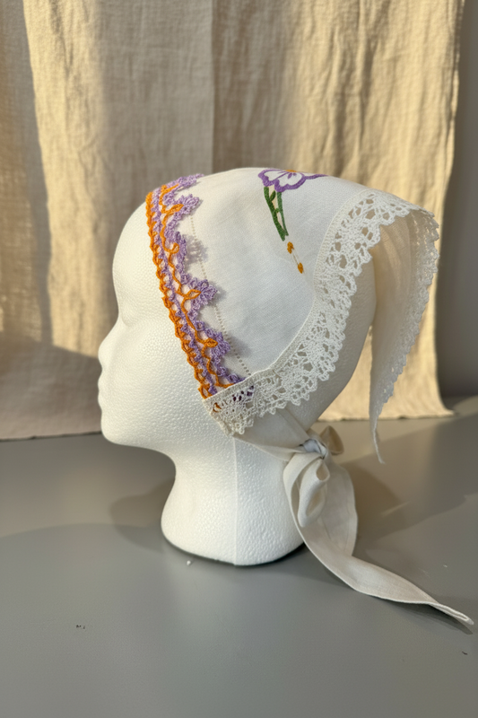 Side View, One-of-two embroidered linen head scarf made from a reclaimed dish towel with floral detail and lace trim. 