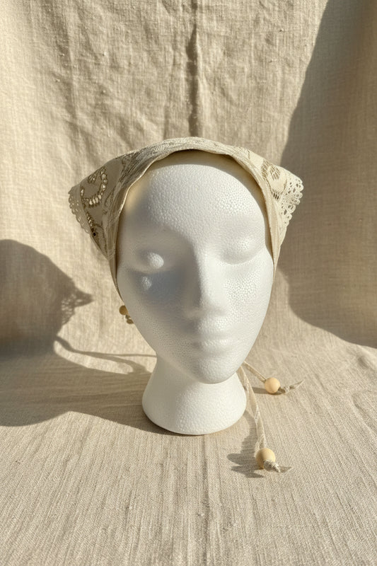 Front view of ivory & tan floral lace head scarf made from a reclaimed table cloth with lace trim.