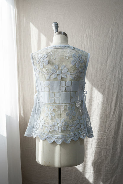 Light blue lace top on a mannequin against a neutral background