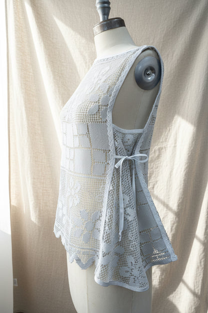 Blue-grey lace top on a mannequin against a neutral background