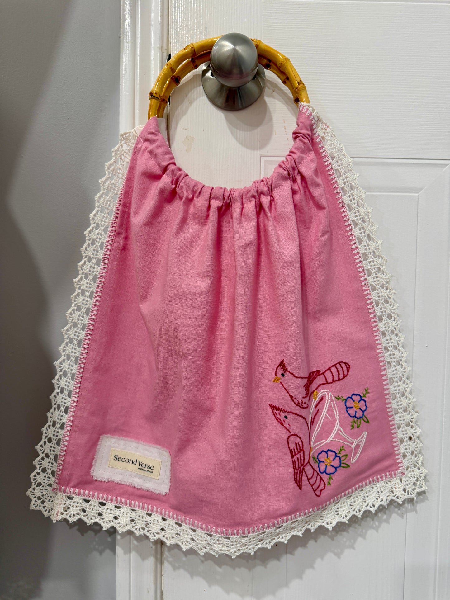 Upcycled embroidered pink tote bag with bamboo handles, close up view