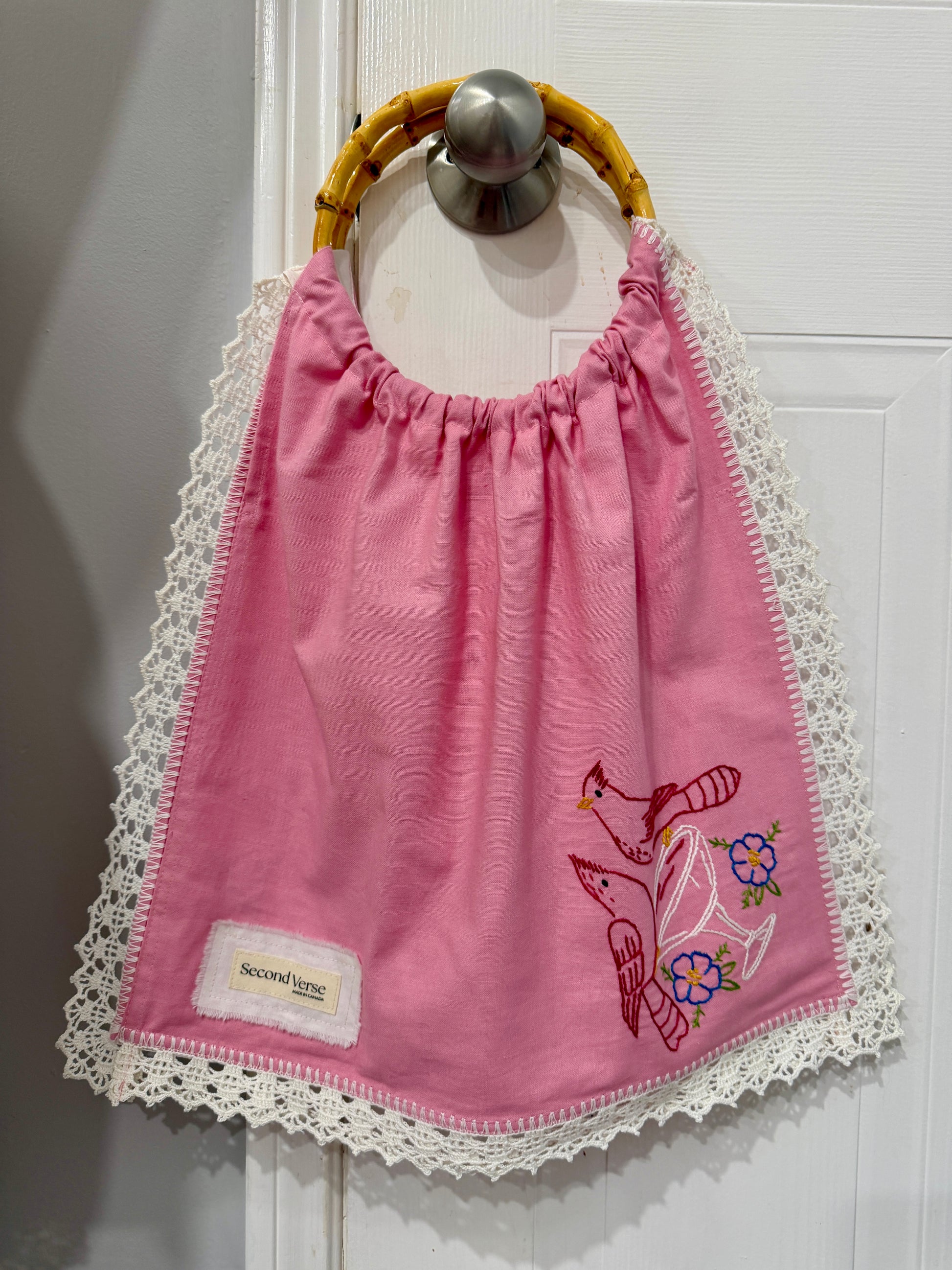 Upcycled embroidered pink tote bag with bamboo handles, close up view