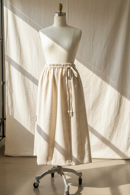 Mannequin wearing a beige skirt with a neutral background