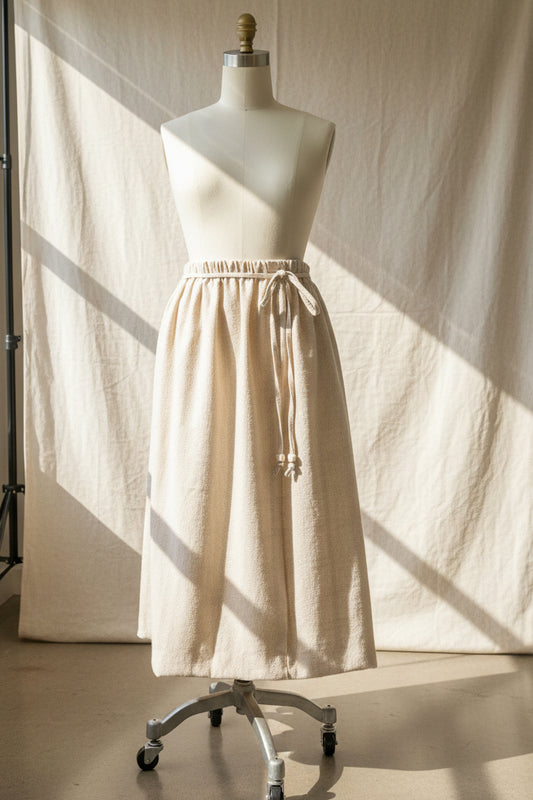 Mannequin wearing a beige skirt with a neutral background