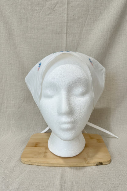 White headscarf on a mannequin head with a beige background
